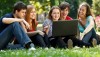 Group of college students using laptop outdoors